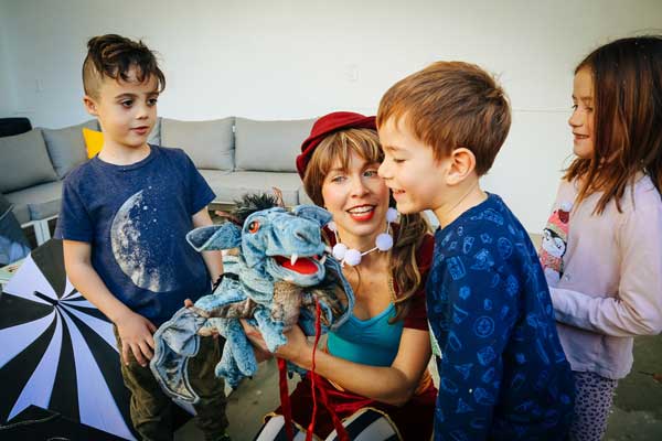 Drea with dragon puppet and children